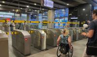 photo of a person in a wheelchair in front of the gates at the Warsaw metro station