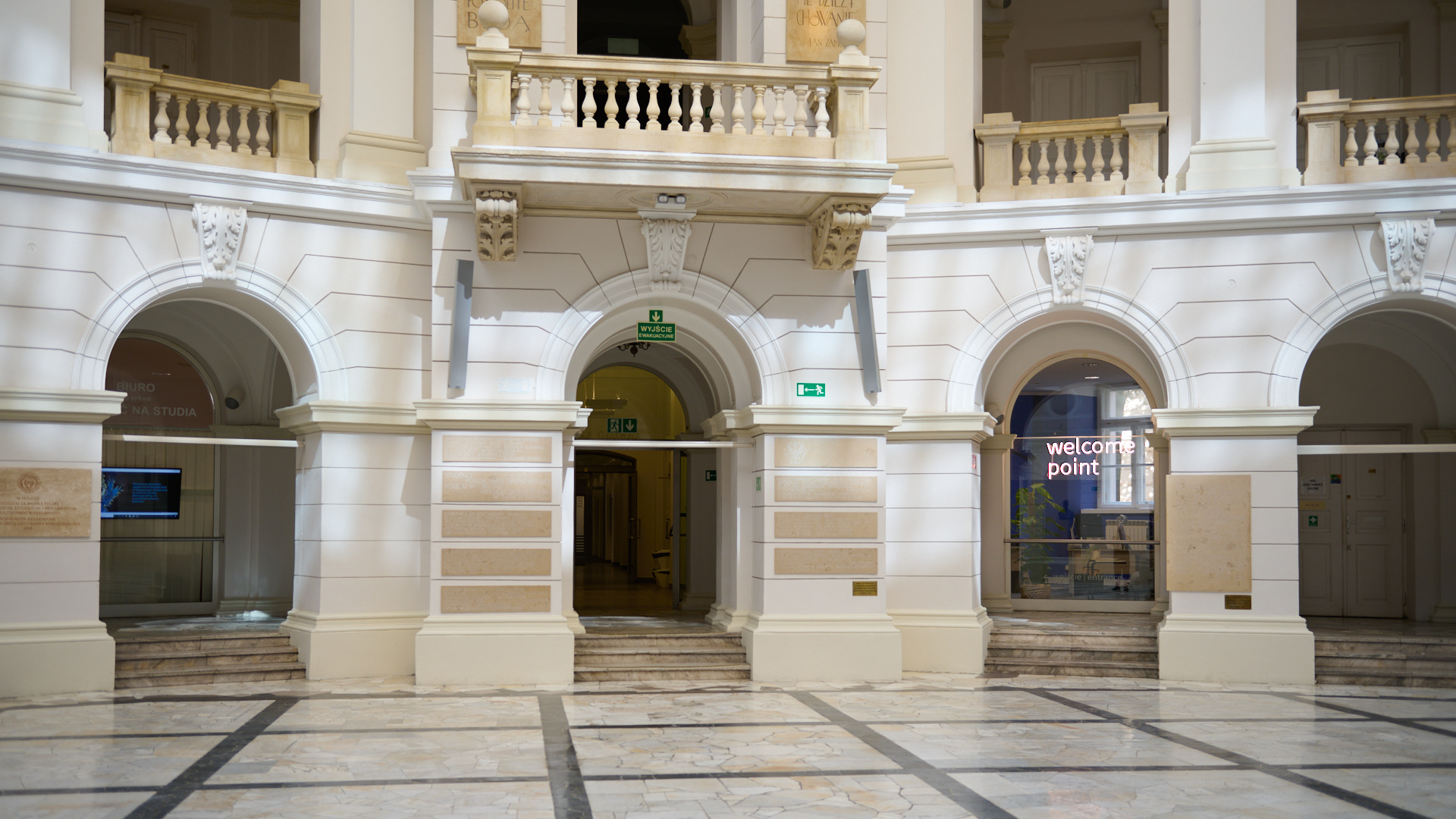 In the photo, the interior of the Main Hall with the Welcome Point neon sign visible in the window is shown