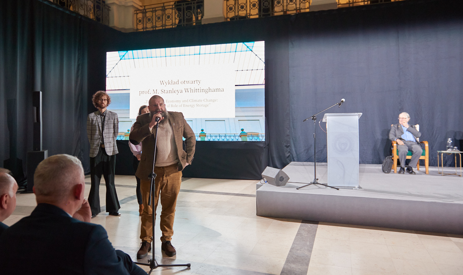 Photo of Prof. Marek Marcinek standing by the microphone