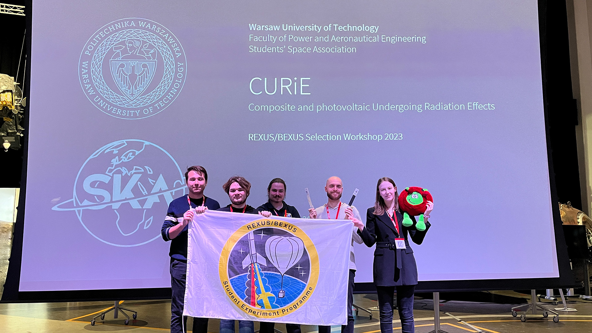 Part of the CURiE team against the background of a project presentation screen