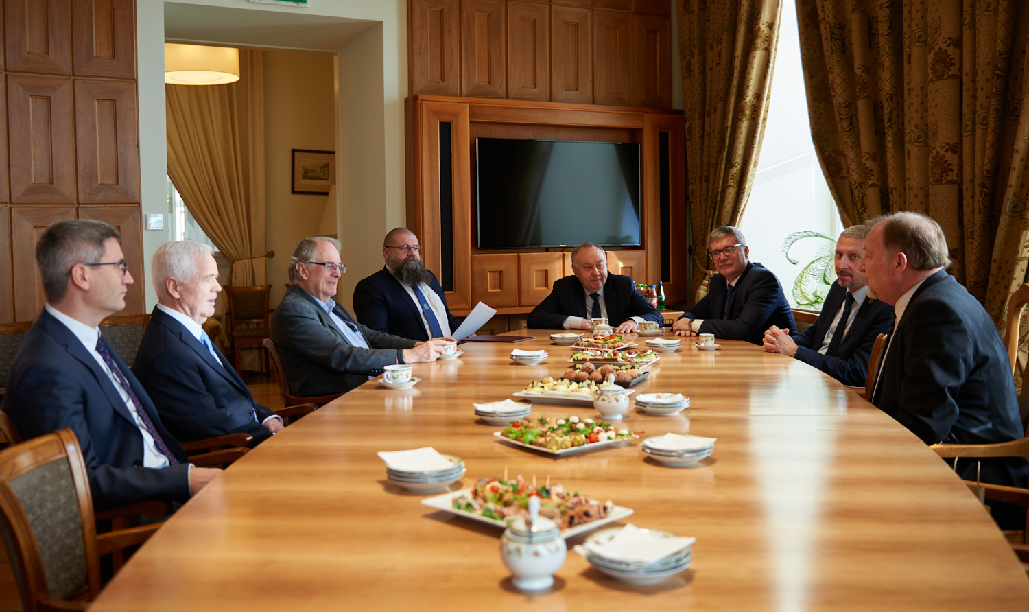 Photo of people sitting at the table during the meeting of M. Stanley Whittingham, WUT authorities and representatives of the Faculties of Chemistry and Physics