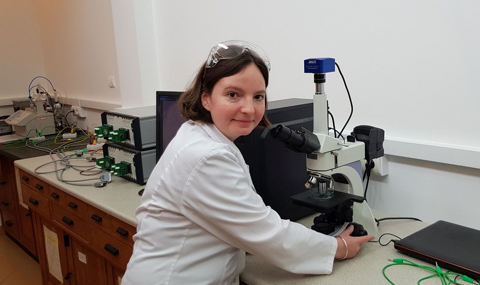 Photo of Marta Kasprzyk, PhD, Eng. at the microscope