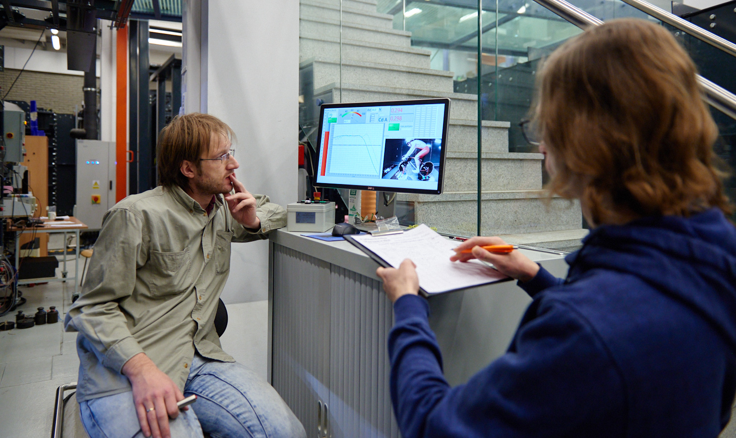 Photo of two men who are sitting at the computer