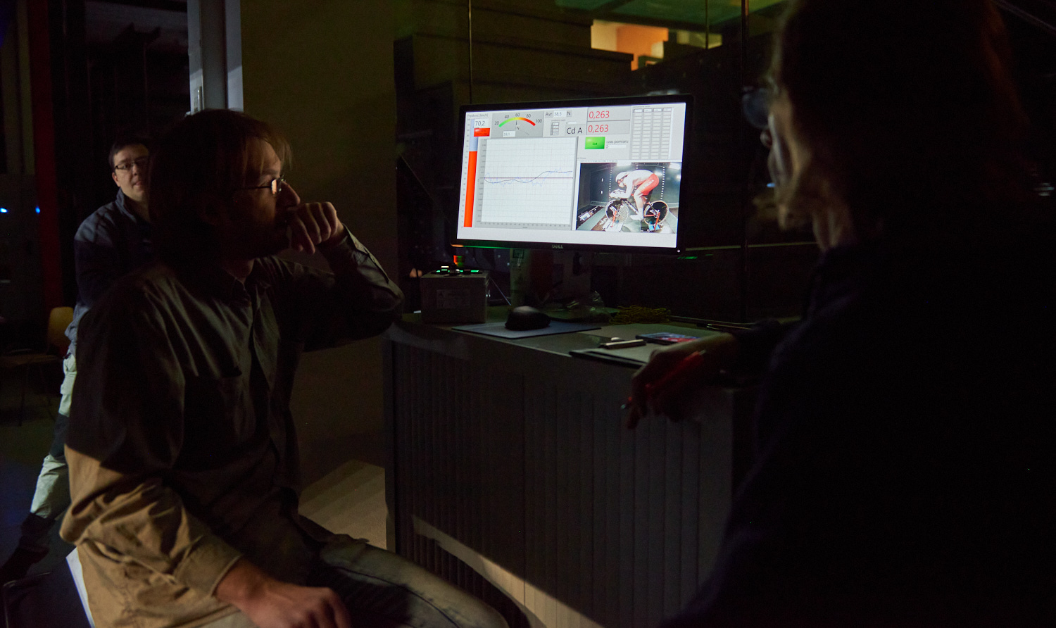 Photo of two men sitting at the computer and the screen where you can see during the measurement
