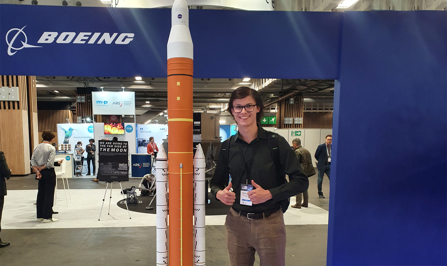 Photo of Szymon in front of the rocket at the International Astronautical Congress 2022