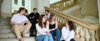 Photo of students who are sitting in the stairs in the Main Building