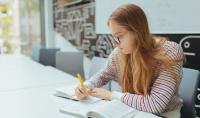 Photo of the student who is sitting and making notes