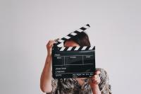 Photo of a woman holding a clapperboard