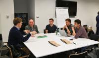 Photo of the one of the teams during the project marathon. Members of the team are sitting by the table and working on their project